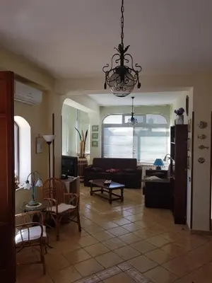a living room with a couch and chairs and a chandelier at Villa del Golfo Urio with swimming pool shared by the two apartments it is essential to have a car in Santa Flavia