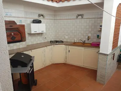 a kitchen with white cabinets and a stove in it at Villa del Golfo Urio with swimming pool shared by the two apartments it is essential to have a car in Santa Flavia
