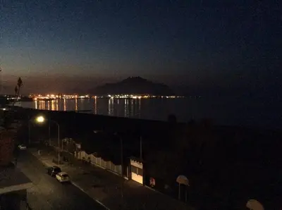 a view of the ocean at night with a mountain at Palazzo Scavone in Palermo
