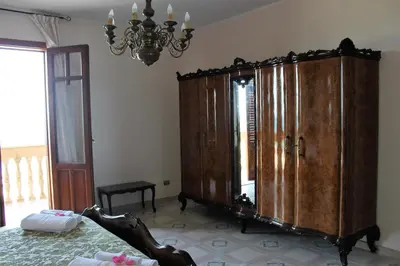 a bedroom with a large wooden cabinet and a bed at Palazzo Scavone in Palermo