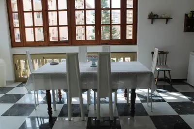 a dining room with a table and chairs and windows at Palazzo Scavone in Palermo