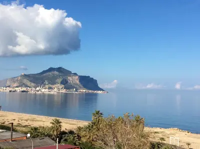 a view of the ocean with a mountain in the background at Palazzo Scavone in Palermo