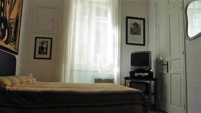 a bedroom with a bed and a tv and a window at Bobnb in Palermo