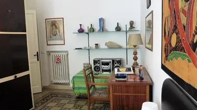 a room with a desk and a table with a radio at Bobnb in Palermo
