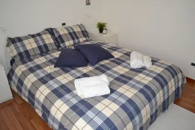 a blue and white plaid bed with towels on it at Appartamento Alla Zisa in Palermo