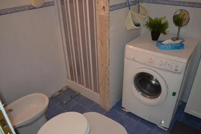 a bathroom with a washing machine and a toilet at Appartamento Alla Zisa in Palermo