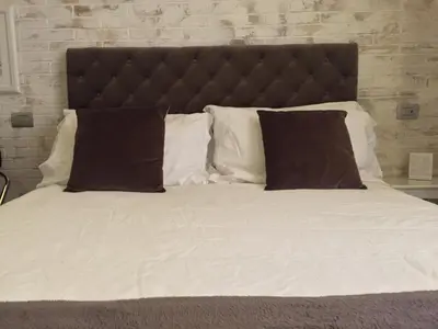a bed with white sheets and brown pillows at 29 Venti Luxury in Palermo