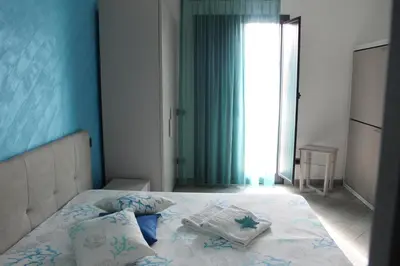 a bedroom with a bed with a blue wall at Monte Monaco B&B in San Vito lo Capo