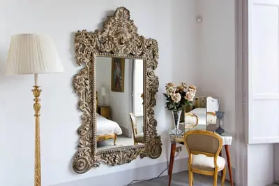 an ornate gold mirror on a wall in a bedroom at Piazza Marina Chic in Palermo