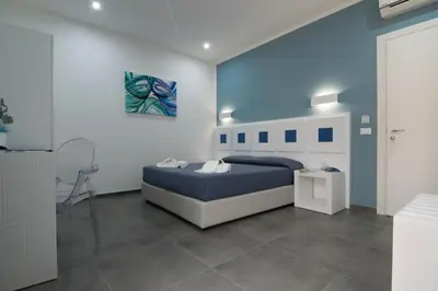 a bedroom with a bed and a painting on the wall at Pharos in San Vito lo Capo