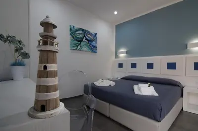 a bedroom with a bed and a lighthouse in it at Pharos in San Vito lo Capo