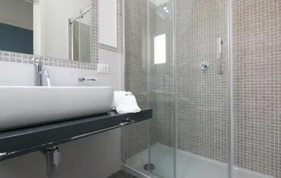 a bathroom with a sink and a glass shower at Pharos in San Vito lo Capo