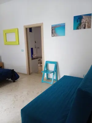 a bedroom with a blue bed and a blue chair at Appartamenti Blu Mare in Castellammare del Golfo