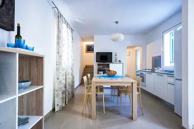 a kitchen and dining room with a table and chairs at Lisca Bianca in San Vito lo Capo