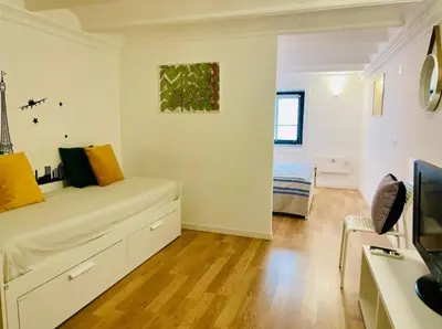 a white room with a bed and a television at Home Maletto in Palermo