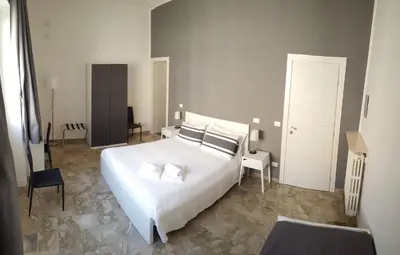 a bedroom with a large white bed and a chair at B&B Casa Rosellina in Palermo