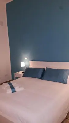 a large white bed with blue walls and a blue wall at B&B Casa Rosellina in Palermo
