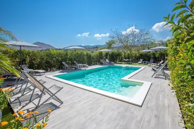 a swimming pool in a yard with chairs around it at Le Zagare in Lascari