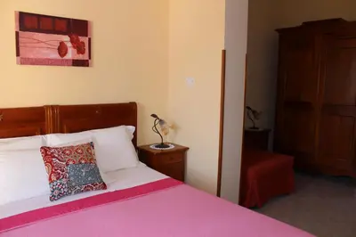 a bedroom with a bed with a pink blanket at Raggio di Sole Bed & Breakfast in Macari