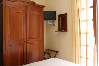 a bedroom with a wooden cabinet and a bed at Raggio di Sole Bed & Breakfast in Macari