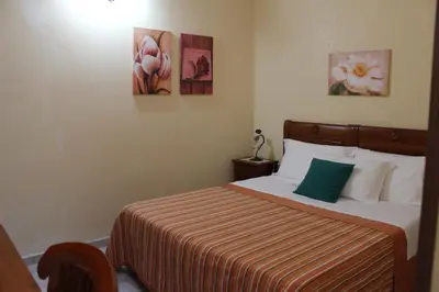 a bedroom with a bed and two paintings on the wall at Raggio di Sole Bed & Breakfast in Macari