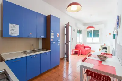 a kitchen with blue cabinets and a red chair at Villa Mondello in Mondello