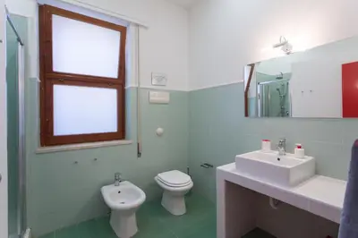 a bathroom with a toilet and a sink and a mirror at Villa Mondello in Mondello