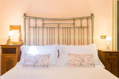 a bed with white pillows and a metal headboard at B&B Porta Carolina in Palermo