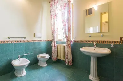 a bathroom with two toilets and a sink and a mirror at B&B Porta Carolina in Palermo
