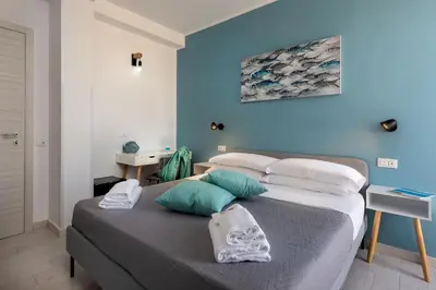 a bed in a room with a blue wall at Samira in San Vito lo Capo