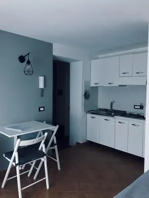 a kitchen with white cabinets and a table and chairs at Le Quattro Chiavi in Palermo
