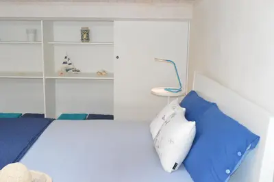a bedroom with a bed with blue and white pillows at Le Gemme di Sicilia Apartments in Castellammare del Golfo