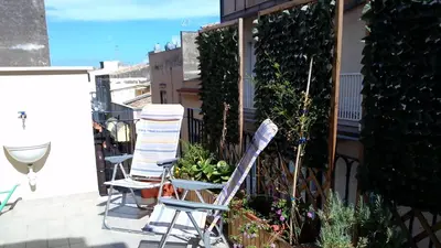 two chairs sitting on a balcony with plants at Le Gemme di Sicilia Apartments in Castellammare del Golfo