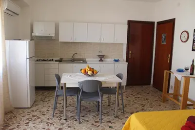 a kitchen with a table with a bowl of fruit on it at Appartamenti Via Marconi in Castellammare del Golfo