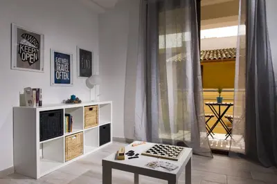 a white living room with a table and a window at La Suite Di Tyche in Castellammare del Golfo