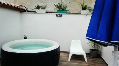 a bath tub with a white chair and a blue umbrella at La Suite Di Tyche in Castellammare del Golfo
