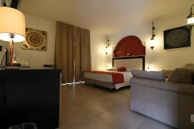 a hotel room with a bed and a couch at RIAD Comfort Rooms in San Vito lo Capo