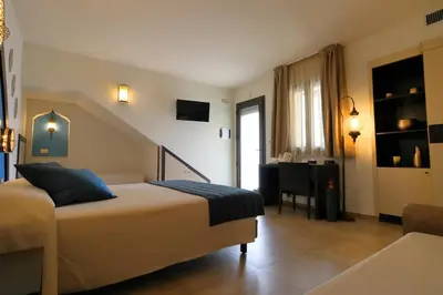 a bedroom with a bed and a table in it at RIAD Comfort Rooms in San Vito lo Capo