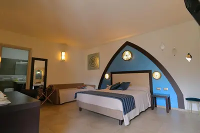 a hotel room with a bed and a living room at RIAD Comfort Rooms in San Vito lo Capo