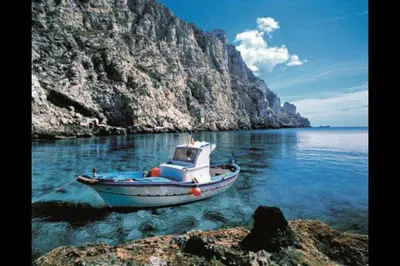 a boat in the water next to a mountain at Casa Josephine in Balestrate