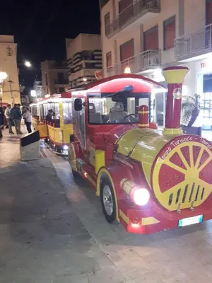 a red and yellow train engine parked on a street at Casa Josephine in Balestrate