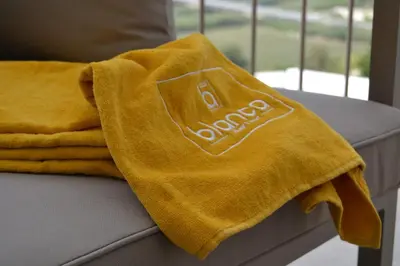 a yellow towel sitting on top of a couch at La Blanca Resort & Spa in Castellammare del Golfo