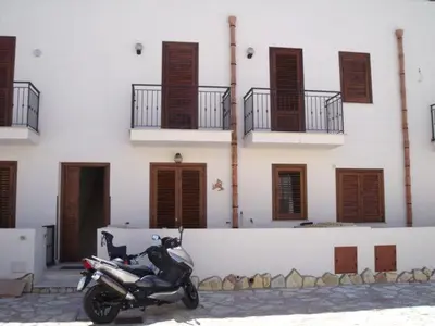 a motorcycle parked in front of a building at Case nel Giardino in San Vito lo Capo