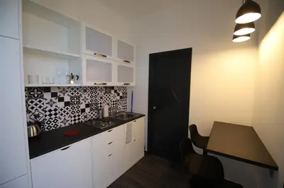 a kitchen with white cabinets and a black counter top at Le Cupole Design in Palermo