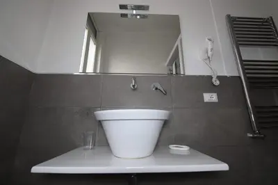 a bathroom with a white sink and a mirror at Le Cupole Design in Palermo
