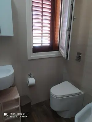 a bathroom with a toilet and a sink and a window at Il Peperoncino in San Vito lo Capo
