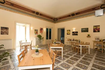 a large room with tables and chairs and a kitchen at Antica Dimora in Palermo