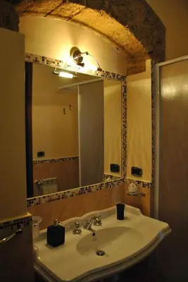 a bathroom with a sink and a large mirror at Antica Dimora in Palermo