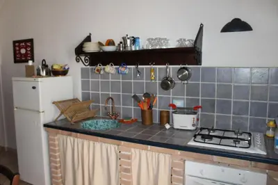 a kitchen counter with a stove and a refrigerator at Soleluna in Castellammare del Golfo