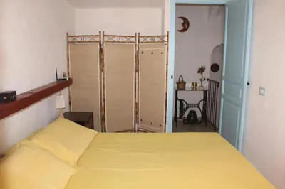 a bedroom with a yellow bed and a closet at Soleluna in Castellammare del Golfo